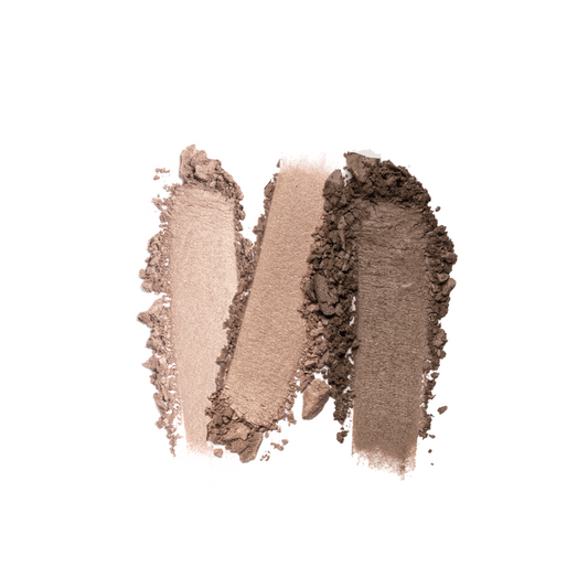 Three overlapping swatches of brown makeup powder in light to dark shades are smeared on a white background, showcasing the texture and pigmentation of Nikol Beautys Le Bottled Blonde 3-Well Eyeshadow Palette, a clean beauty must-have with a vegan formula for a guilt-free glow.