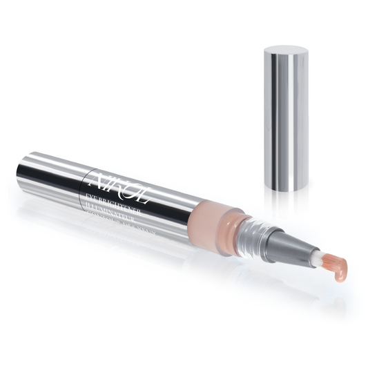 The Nikol Beauty Eye Brightener is a sleek, silver pen-style applicator with a transparent section revealing the nude-tone product. Remove the cap to uncover the brush tip coated with brightener, enhanced with Chamomile Flower Water for gentle application.