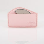 A pink leather pouch embossed with Nikol Beauty holds the Gua Sha Stainless Steel tool, partially visible inside and ideal for lymphatic drainage, set against a white background.