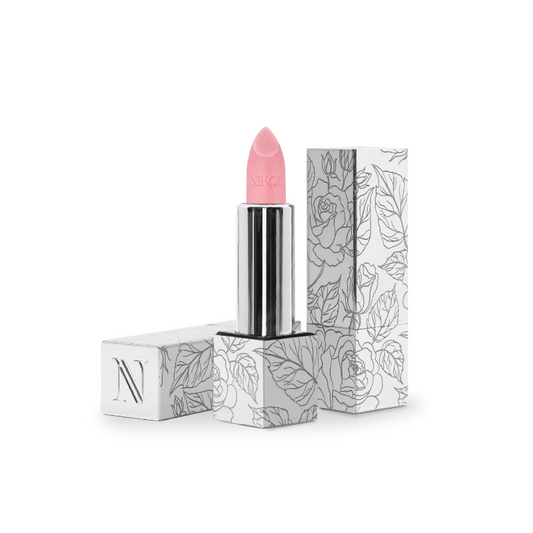 Rose Lip Balm #100 by Nikol Beauty comes in a pink hue encased in a sleek silver tube, housed within a floral-patterned white box adorned with N. This vegan product also functions as a hydrating balm for smooth, moisturized lips all day.