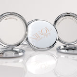 Three round, silver Fierce Aging Mini Compact Mirrors from Nikol Beauty stand open—one reads NIKOL Faster Aging, while the sides say NOTHING TO FIX and I’VE EARNED THESE LINES!, celebrating confidence and portable beauty.