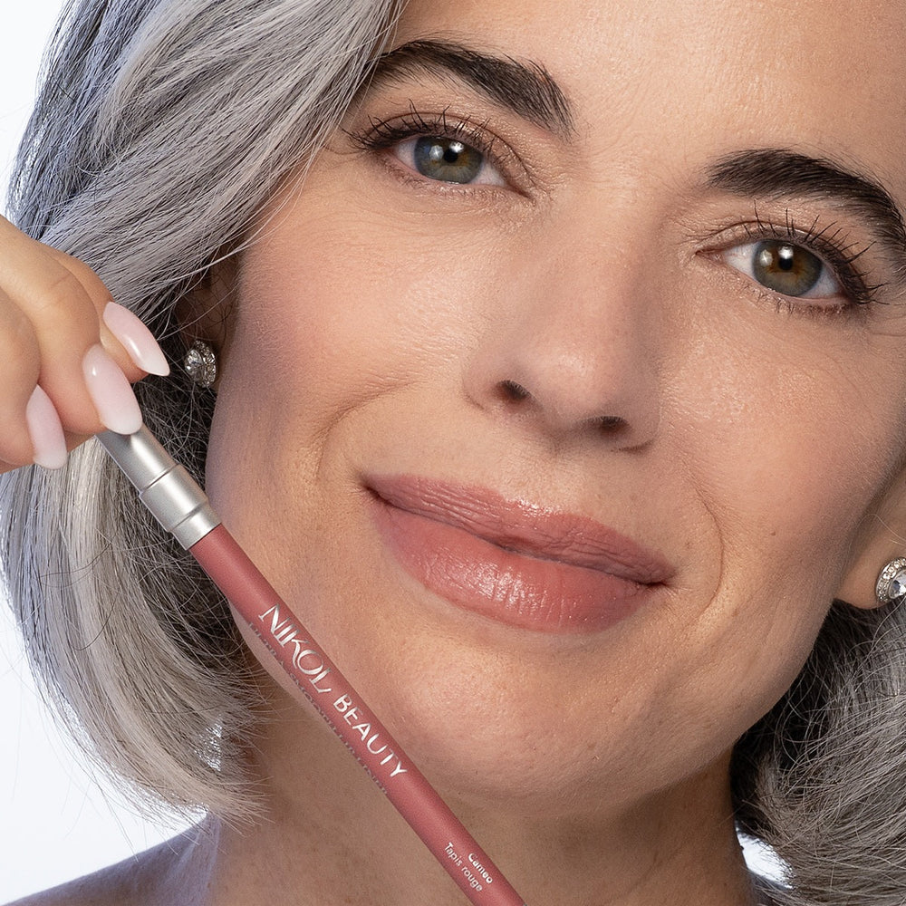 Nikol smiling with softly lined and filled lips, holding the Cameo WaterProof Lip Liner Pencil