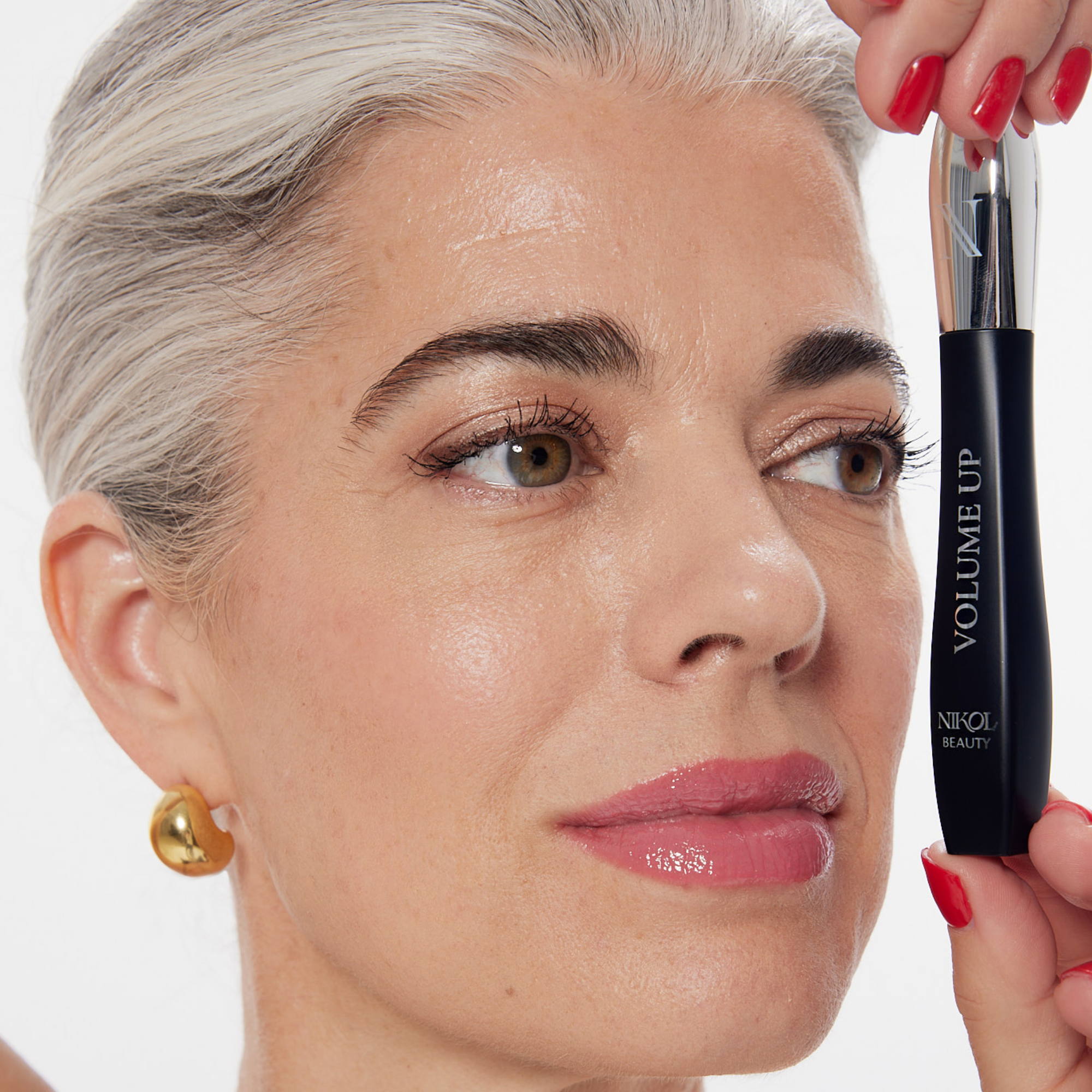 Nikol holding the closed VOLUME UP Mascara beside her face