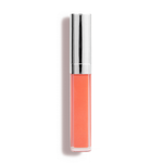 A tube of Nikol Beautys Defiance Lip Gloss #62, coral-colored with a shiny silver cap, known for its high-impact shine and non-sticky finish, stands upright against a white backdrop.