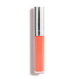 A tube of Nikol Beautys Defiance Lip Gloss #62, coral-colored with a shiny silver cap, known for its high-impact shine and non-sticky finish, stands upright against a white backdrop.